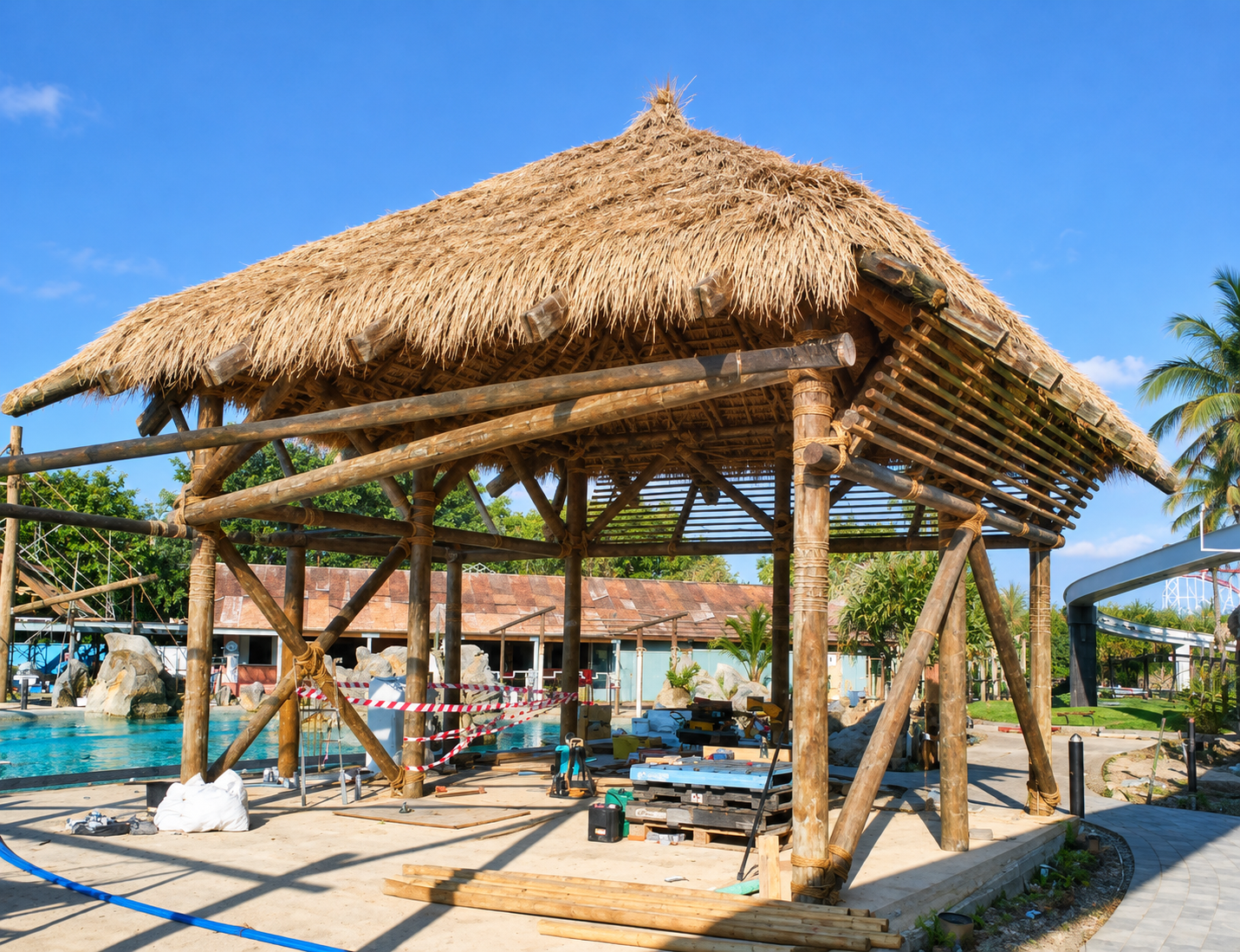 Thatched Balinese pavilion under construction beside a pool