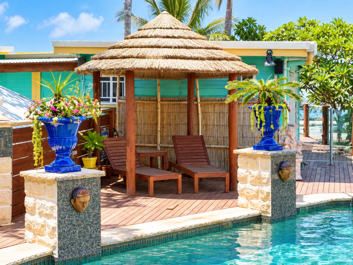 Tiered gazebo roof above seating beside a pool