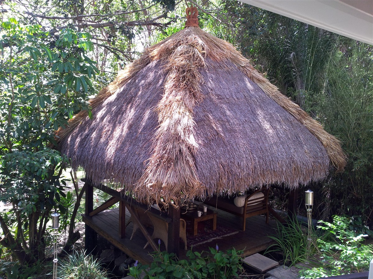 Thatched Bali hut with hip coverings running down the roof corners