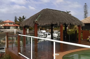 Side view of the brushwood gazebo beside the pool fence