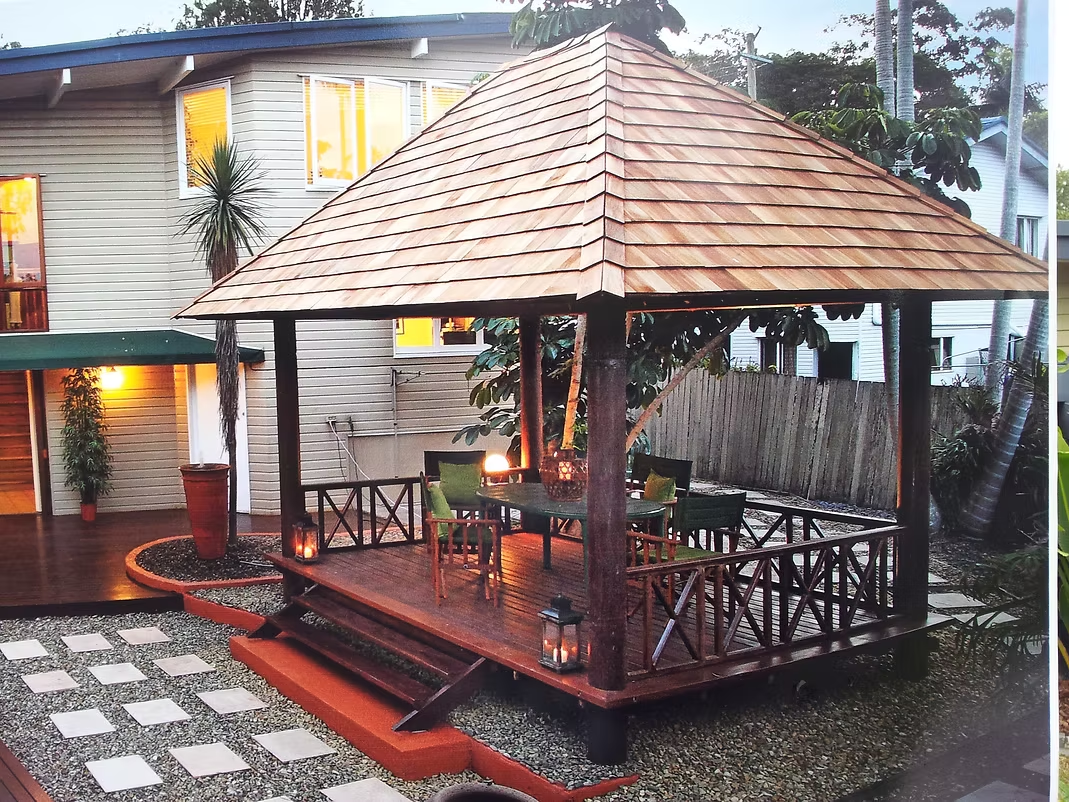 Canadian Red Cedar shingle gazebo with raised deck and cross-pattern handrails at dusk